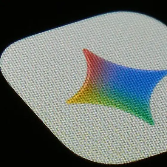 スマートフォン画面に表示された、赤から青へ虹色にグラデーションした星型アイコンのクローズアップ